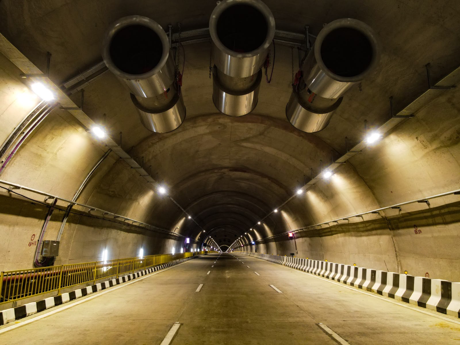 Completed road tunnel with jet fans and lit carriageway